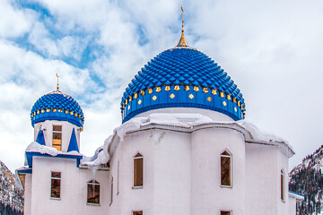 Mosque with blue domes against the sky with clouds