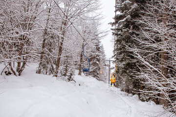 Open cable car in a snowy winter forest