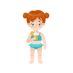 Cute baby girl standing and drinking orange juice. Adorable child with red hair and freckles on summer vacations.
