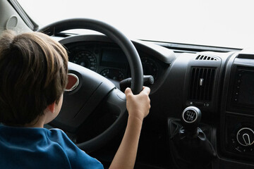 Little boy kid day dreaming about driving a mobile home, rv. Kid learning to drive.