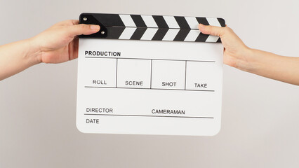 Two hands send and hold white clapper board or movie slate on white background.