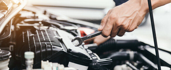 Automobile mechanic repairman hands repairing a car engine automotive workshop with a wrench, car...