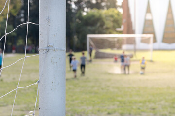 Selective focus on a soccer goal and background game.