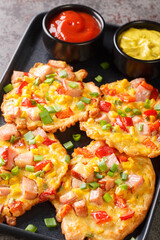 Vegetable pancakes with ham served with sauce close-up on a plate on the table. vertical