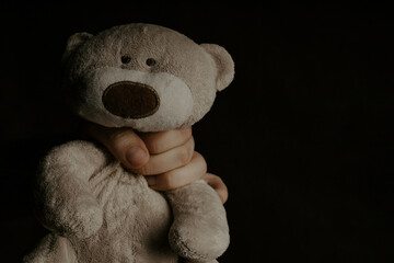 Man holds a teddy bear close-up. Abuse, violence or punishment concept