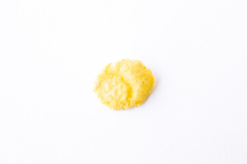 one golden inflated corn flake isolated on white background top view, macro, close-up