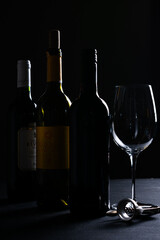 Bottles of white and red wine on a dark background