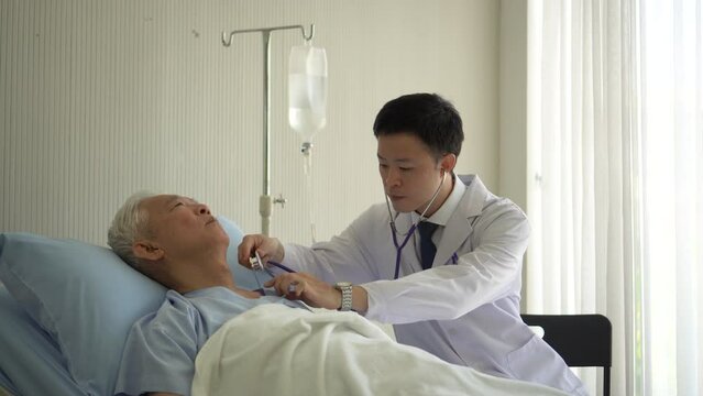 Asian doctor checking senior patient heart pulse rate while admit in hospital