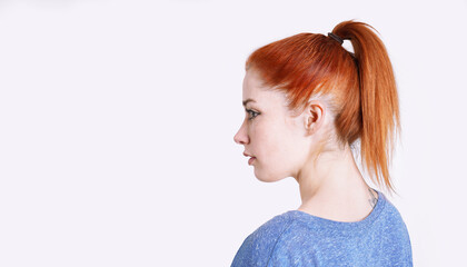 young woman with dyed red hair tied back in a ponytail with scrunchie