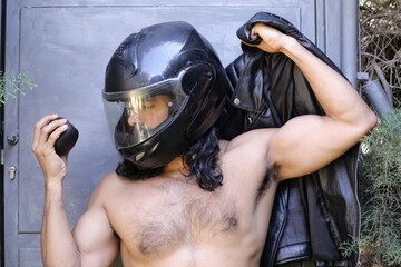 Long haired biker wearing a helmet holding a black apple