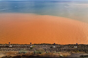 drone shot of a fishing area with multicoloured seawater