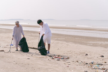 Senior couple garbage clean up on the beach 