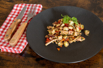 garlic squid salad in a plate on a wooden table