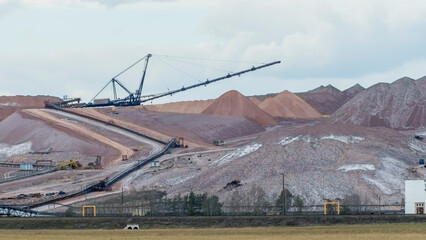 Giant spreader or absetzer machinery. A large dumper on a landfill with potash ore. Extracting potassium salts.