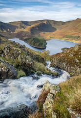 Naklejka na ściany i meble A view down a picturesque waterfall to Rannerdale in the Lake District, a scenic area of beauty