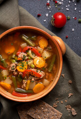 Vegetable soup on dark background, hot healthy food