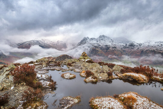 Atmospheric winter view of stormy weather on Lake District fells with snow on the summits