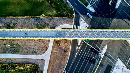 top down drone shot of a footbridge over a road