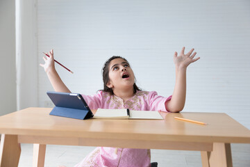 cute Indian girl smiling and raise hands pose after finished online learning class, education concept