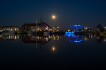 The old inland port of Emden with the blue bridge under a full moon