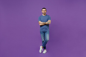 Full body young smiling happy cheerful fun man 20s wearing basic blue t-shirt hold hands crossed...