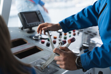 Detail of a man's hands using the controls to drive a boat.