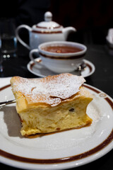 Austrian sweet dessert, filled with white cheese strudel served warm in traditional cafe in Vienna, Austria with cup of black tea