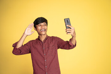 happy asian man taking selfie with phone camera on isolated background