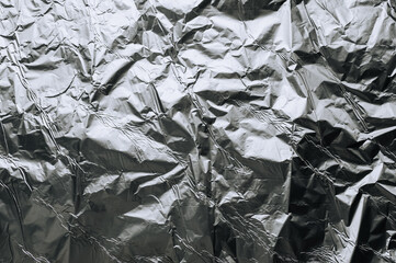Background, texture of silver shiny foil, colored crumpled paper. Photo, top view, copy space.