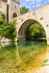 San Vittore alle Chiuse. Roman Catholic abbey and church. The edifice is known from the year 1011. Ponte Romano. Roman bridge over a small river. Italy.