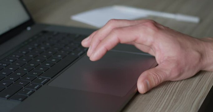 Male Hand Touching Mousepad On Laptop