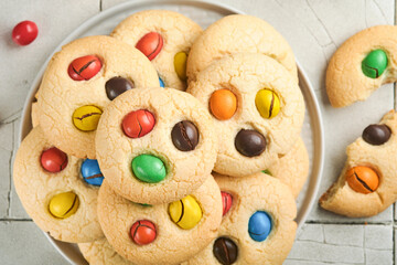 Homemade cookies with colorful chocolate candies and milk. Stack of shortbread cookies with multi...