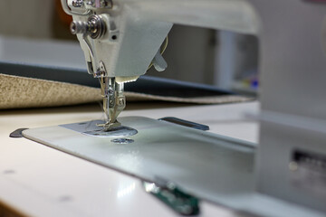 Close-up of a sewing machine. Professional sewing machine in the workplace. Factory for the production of fabric products