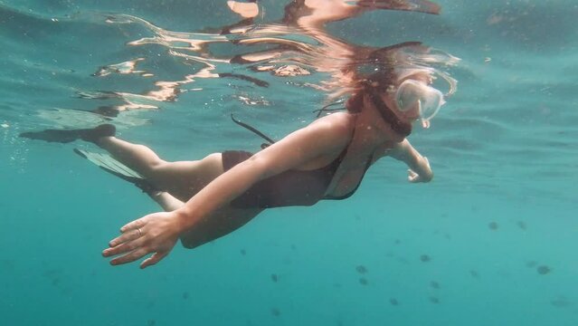 Theres no place quite like the ocean. 4k video footage of an attractive young woman swimming wearing snorkeling gear in the deep blue ocean.
