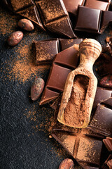 Chocolate and cocoa powder. Composition of cocoa powder, grated and bean cocoa bars and pieces of different milk and dark chocolate on black background. Baking Chocolate Texture. Top view. Mock up.