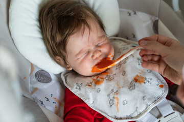 First meal problems concept small caucasian baby five months old refusing to eat spitting organic...