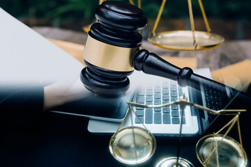 Obraz premium Justice and Law concept. Legal counsel presents to the client a signed contract with gavel and legal law or legal having team meeting at law firm in background