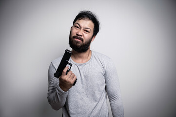 Asian handsome man angry on white background,Portrait of young Stress male concept,Hold gun in hand