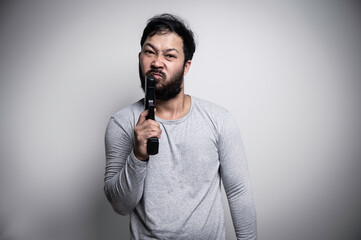 Asian handsome man angry on white background,Portrait of young Stress male concept,Hold gun in hand