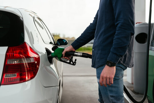 Anonymous man refilling vehicle tank at petrol station