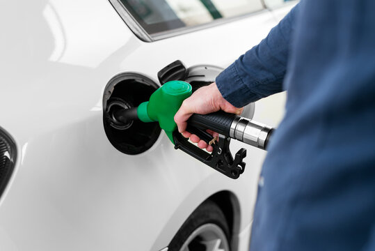 Anonymous man refilling vehicle tank at petrol station