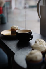 A cup of coffee and cakes on a table