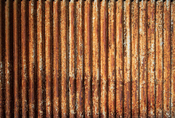 Background from an old rusty metal surface with a wavy relief and peeling paint
