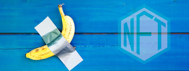 Horizontal banner or header with yellow banana duct-taped to a blue wooden wall - Modern art and non fungible token concept - New Technology Token Concept