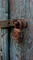 The rusty padlock and old wood paint has peeled off