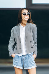 Fashionable pretty woman walking on the city street.