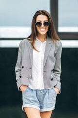 Fashionable pretty woman walking on the city street.