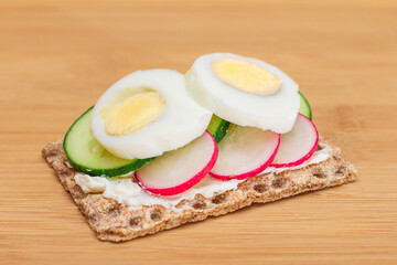 Whole Grain Crispbread with Fresh Cucumber, Egg, Cream Cheese and Radish on Bamboo Cutting Board. Easy Breakfast. Quick and Healthy Sandwiches. Crispbread with Tasty Filling. Healthy Dietary Snack