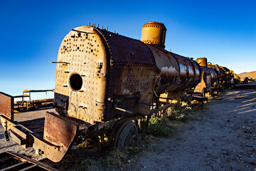 Fototapeta na wymiar Train Cemetery in Uyuni, Old rusty trains, railway museum at sunset lights, Uyuni, Bolivia