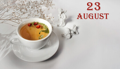 calendar date on light background with a porcelain cup of green tea, white gypsophila and angels with copy space. August 23 is the twenty-third  day of the month